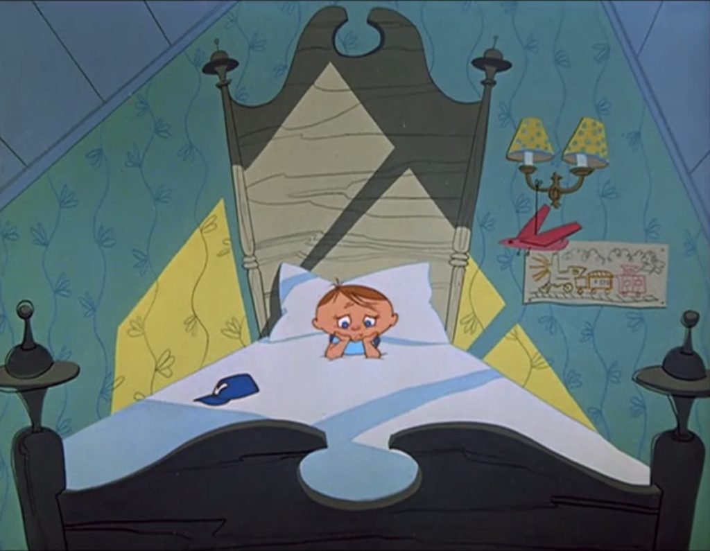 A small boy with a sad expression lies in bed, looking over the top of his blankets.