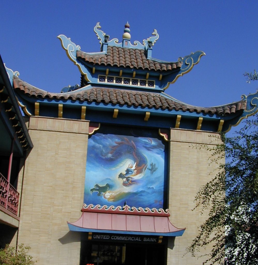 United Commercial Bank building with a tiled, tiered pagoda-style roof and a large mural of a dragon on the exterior wall.
